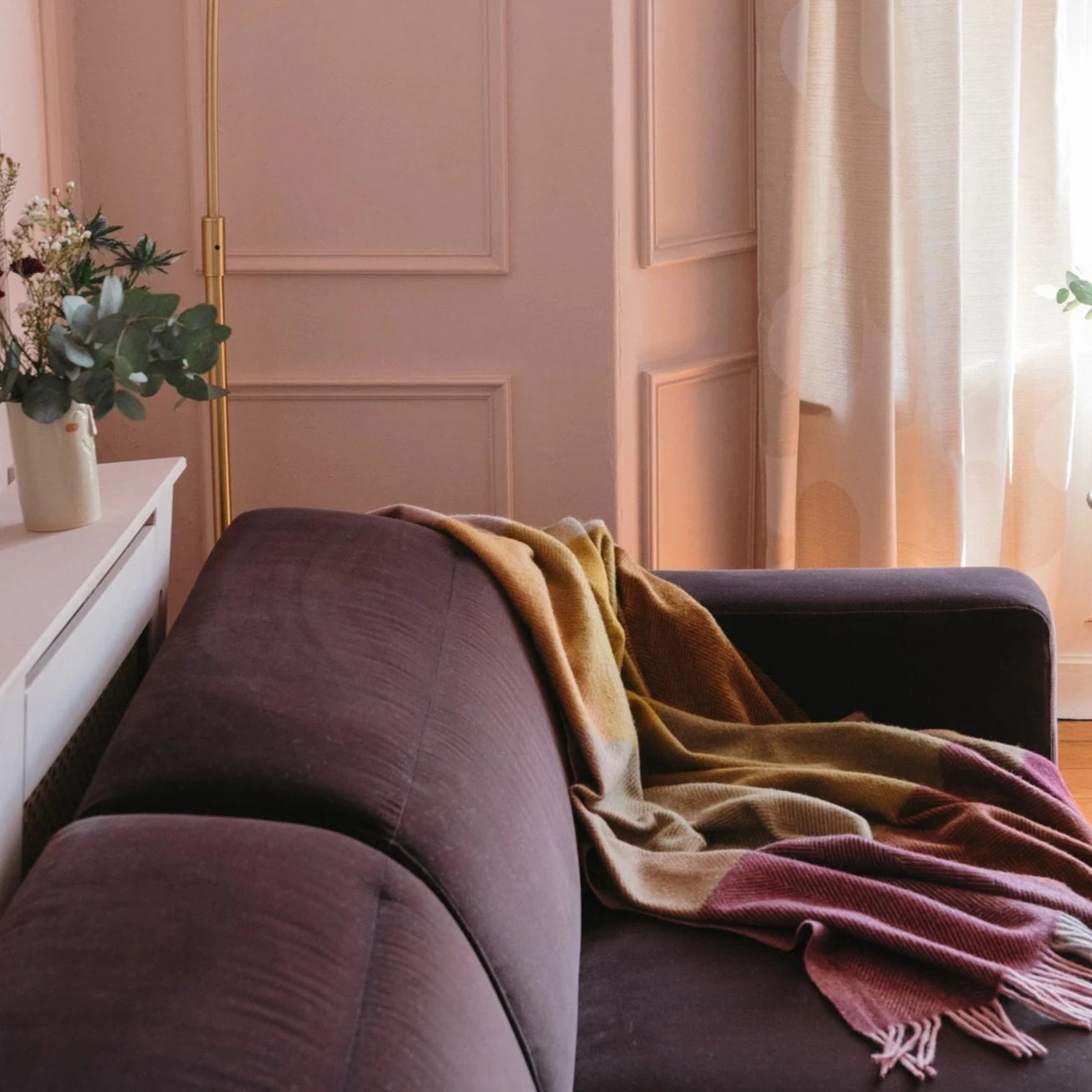 Blanket draped on a maroon couch