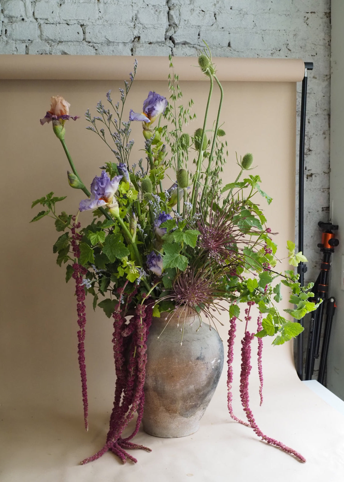 Bouquet of flowers in a vase against a plain wall with a radiator below.