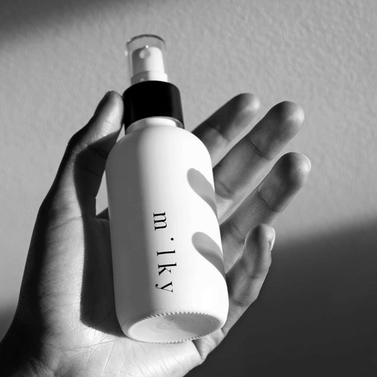 Riddle Milky Spray Lotion 120ml bottle in a person's hand